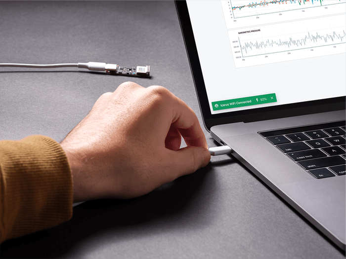 Hand plugging USB connector into laptop, display shows connection alert